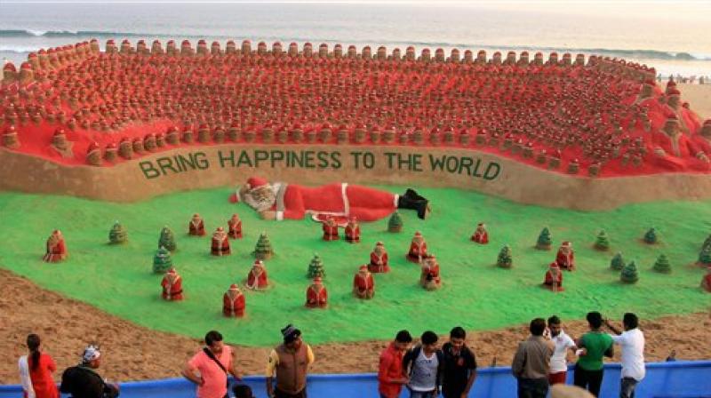 Sudarshan Pattnaik creates 1,000 Santa Clauses from sand in an attempt to make a world record at Puri beach in Odisha on Saturday. (Photo: PTI)