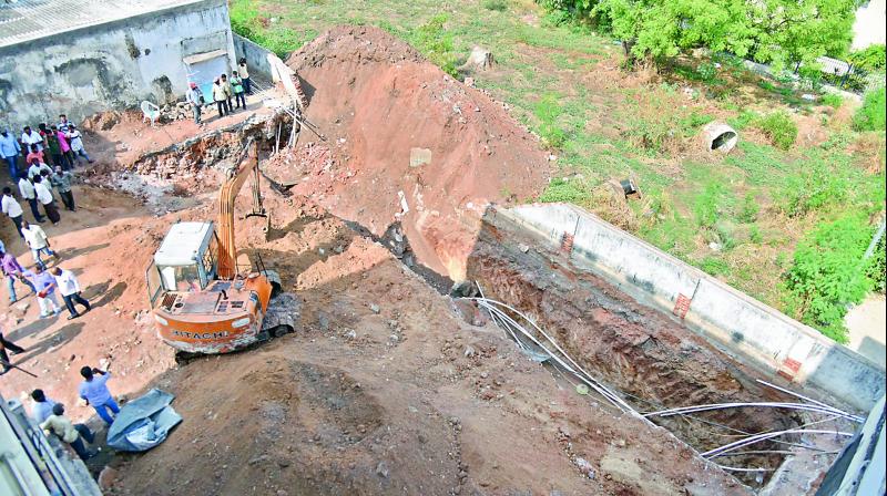 Workers remove debris from the site where the wall collapsed at Premnagar in Amberpet on Saturday.  (Image: S. Surender Reddy)