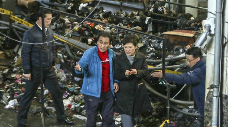 Park Geun-hyes office says she visited the market to review a recent fire, which destroyed hundreds of shops there. (Photo: AP)