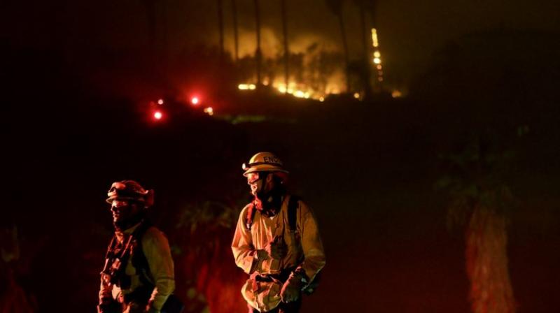 Firefighters battle several intense wind-driven wildfires early on Friday that have swept across densely populated Southern California, destroying at least 500 structures. (Photo: AP)