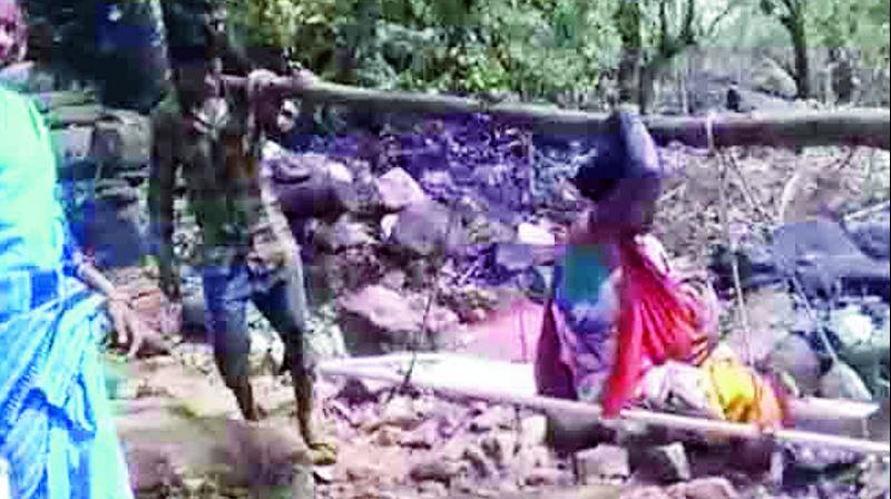 The woman being shifted to an ambulance on a sling in Malkangiri district on Tuesday.