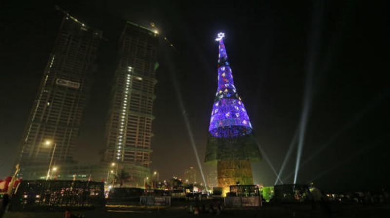 An enormous artificial Christmas tree is seen lit up after its unveiling in Colombo, Sri Lanka, Saturday. (Photo: AP)