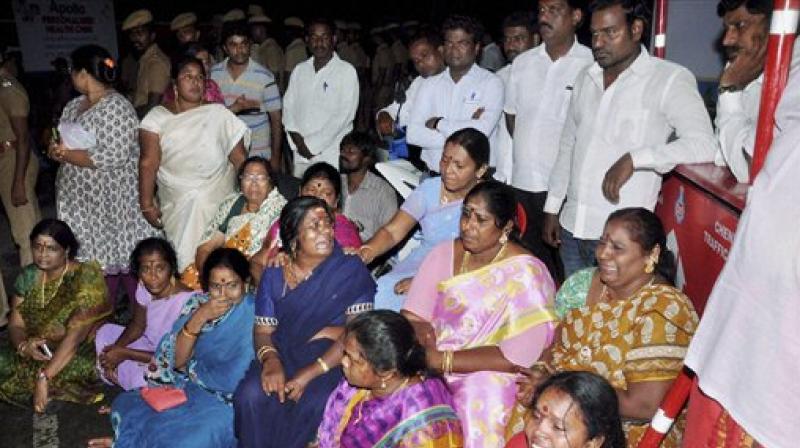 AIADMK supporters sit in front of Apollo Hospital after Tamil Nadu Chief Minister, Jayalalithaa suffered a cardiac arrest in Chennai. (Photo: PTI)