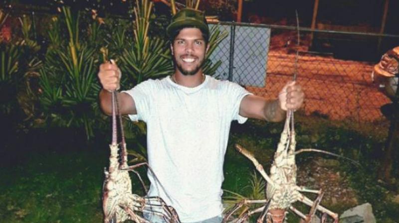 Umesh Yadav posted a rather bizarre picture on Instagram, of himself holding two massive lobsters upside down. (Photo: Umesh Yadav/ Instagram)