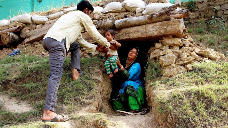 Border migrants take shelter in a bunker after shelling from Pakistan side at Nowshera sector of Rajouri district on Saturday. (Photo: PTI)