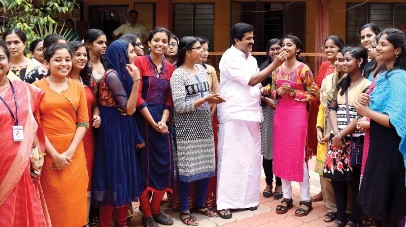 V.S. Sivakumar, MLA, gives sweets to students at the Government Girls Higher Secondary School in Thiruvananthapuram on Thursday. (Photo: DC)