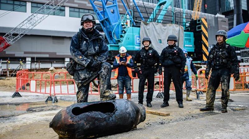 The experts cut a large hole through the shell to burn off explosive materials inside before a crane lifted the earth-covered bomb off the site on Thursday. (Photo: AFP)