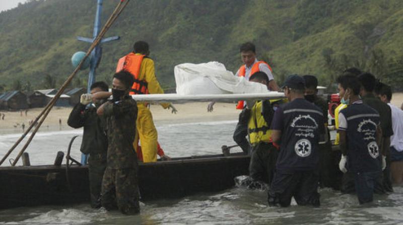 On Thursday recovery workers carried bodies on stretchers back to shore in a grim procession met by solemn lines of locals and relatives waiting under heavy skies on the beach. (Photo: AP)