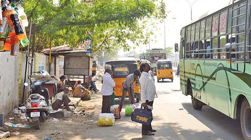 A commuter waits for a bus in the shade of a tree in Koyambedu (Photo: AP)