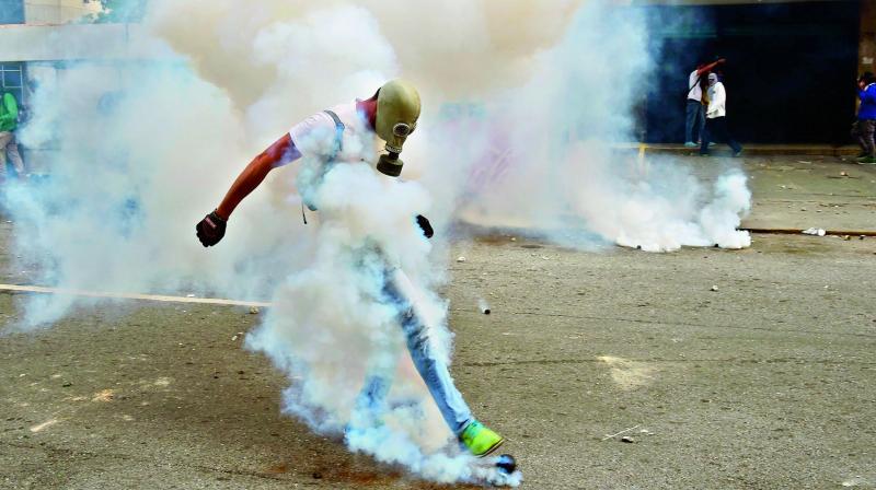 A demonstrator clashes with police during a rally against Venezuelan President Nicolas Maduro, in Caracas on Thursday. (Photo: PTI)