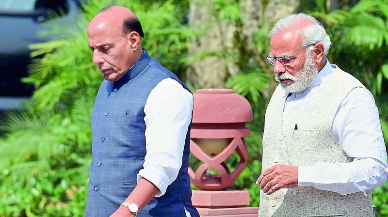 Prime Minister Narendra Modi and Home Minister Rajnath Singh leave after a Cabinet meeting at the Parliament Library in New Delhi on Monday. (Photo: PTI)