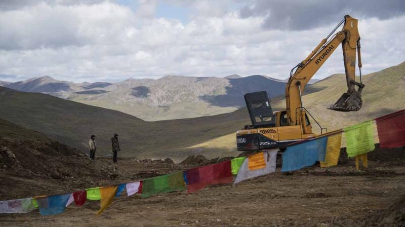 China on Sunday opened a 409-kilometre-long expressway linking Tibets provincial capital Lhasa with Nyingchi. In picture: Buldozers work on a future highway in Nyingchi. (Credit: AFP)