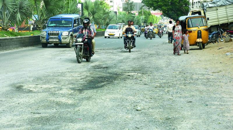 The road damaged by rains at Manikonda signal in the city. (Photo: DC)