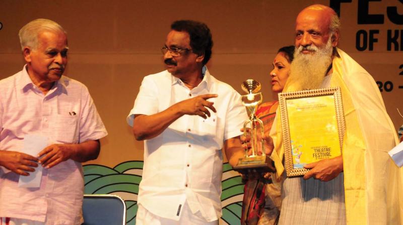 Cultural minister A.K. Balan presents Ammannur award to theatre artiste Prasanna during the inaugural function of 11th International Theatre Festival of Kerala in Thrissur on Sunday.(DC)