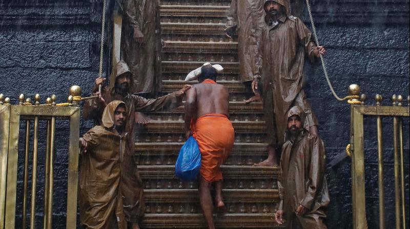 A lone devotee ascends the 18 holy steps on way to sanctum sanctorum amidst heavy rain in Sabarimala. (By Agreement)