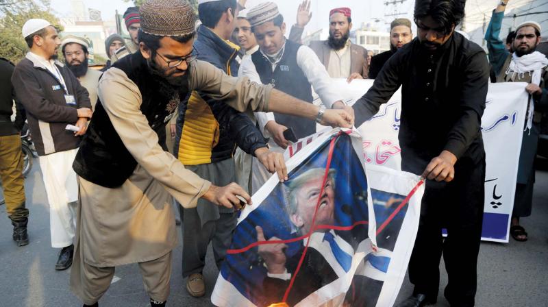 Pakistani protesters burn posters of US President Donald Trump in Lahore.