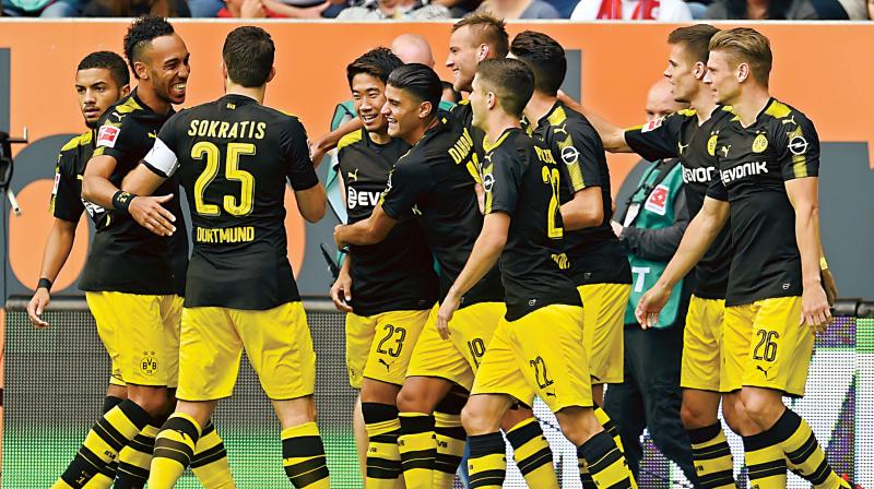 Borussia Dortmund players celebrate the opening goal against FC Augsburg in Augsburg on Saturday.  (Photo: AP)