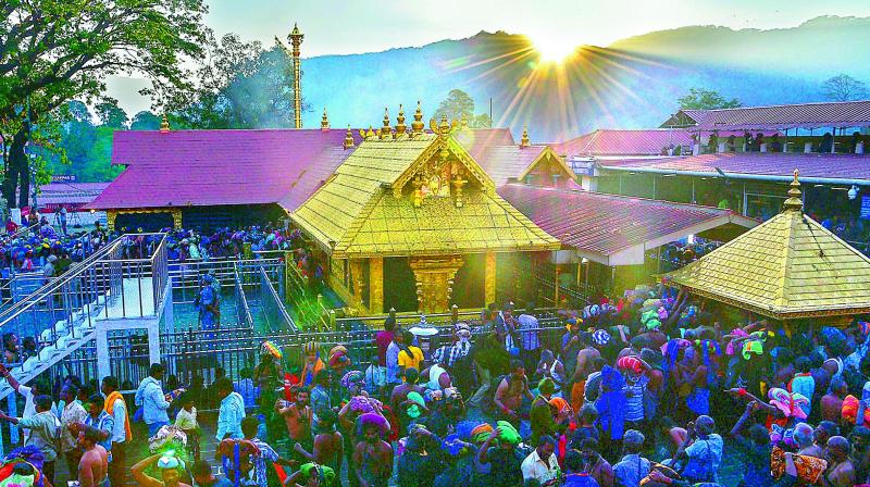 Devotees arrive to offer prayers at the Lord Ayyappa temple in Sabarimala on Friday.  (PTI)