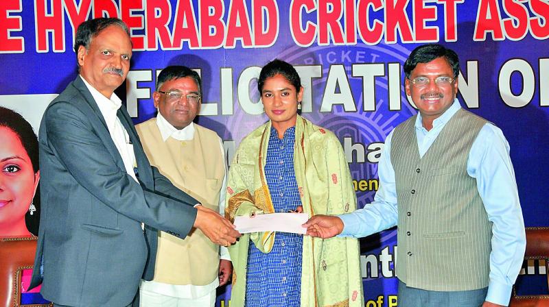 Justice G. V. Seethapathy (from left), former president of HCA G. Vinod and current president G. Vivekanand present a cheque to Mithali Raj during a felicitation function at the RGICS in Hyderabad on Sunday. (Photo: DC)