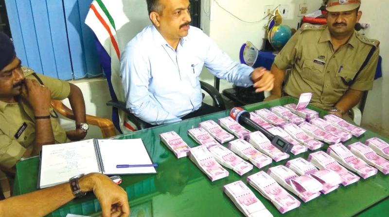 District police chief Debesh Kumar Behera shows the money seized from Manjeri. (Photo: DC)