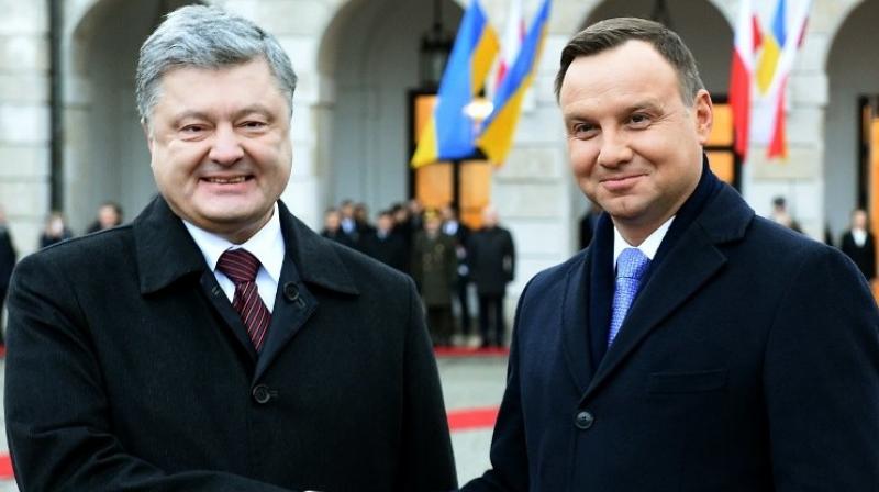 Ukrainian President Petro Poroshenko and visiting President Andrzej Duda of Poland laid flowers on Wednesday at a monument to Polish soldiers killed by Soviet security forces in 1940. (Photo: AFP)