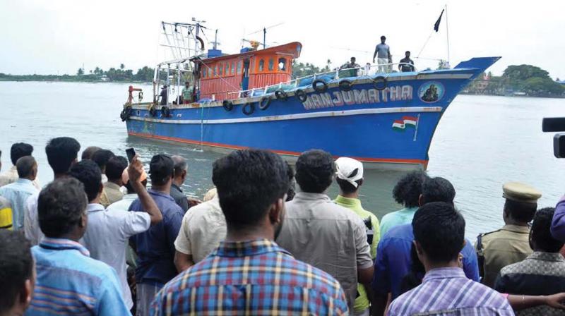 Crowds gather as boat carrying dead bodies of the two fishermen who dies in the mishap arrives ashore on Sunday (Photo: DC)