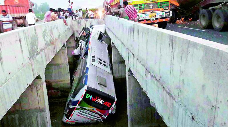 A bus belonging to Diwakar Travels fell off a bridge in the middle of a flyover near Mullapadu village of Penuganchiprolu mandal in Krishna district on Tuesday.