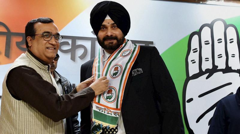 DPCC President Ajay Maken presents the party scarf to Navjot Singh Sidhu as he is welcomed at a press conference a day after his joining the Congress party at AICC headquarters in New Delhi on Monday. (Photo: PTI)