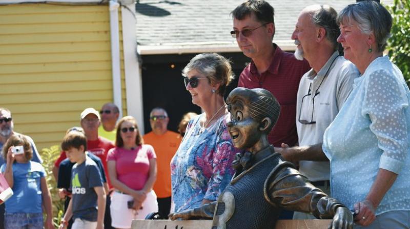 A statue of the comic strip character Archie sits on a park bench, created by sculptor Valery Mahuchy, as it was unveiled in Community Park, Meredith, Thursday, Aug. 9, 2018, as part of the towns 250th anniversary celebration. Archie illustrator Bob Montana lived in Meredith for 35 years and worked many local residents and scenes into the comic strip until his death in 1975 at age 54. Posing with the statue are Montanas children, Paige, Donald, Raymond, and Lynn. (Photo: AP)