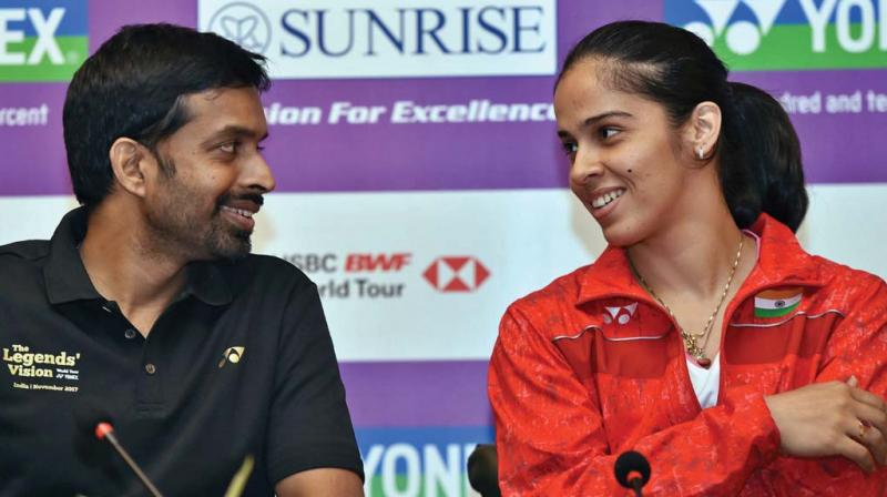 India badminton coach Pullela Gopichand (left) with Saina Nehwal in New Delhi on Tuesday (Photo: AP)