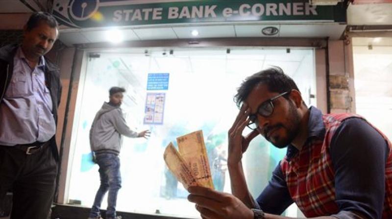 A man looks at his old Rs 500 notes outside a bank. (Photo: PTI)