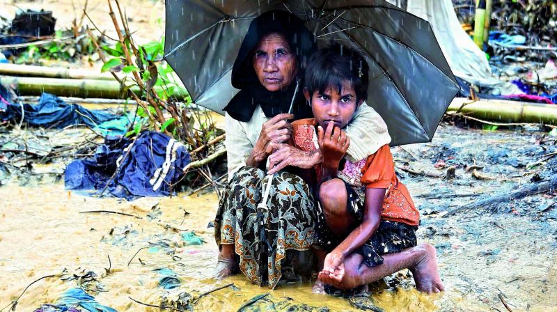Rohingya Muslim refugees protect themselves from rain in Balukhali refugee camp in Bangladesh. (Photo: AFP)
