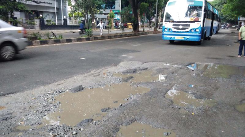 At Koramangala Third block, motorists have to wade through craters and pedestrians using footpaths have to contend with garbage piles, broken and missing slabs. (Photo: DC)