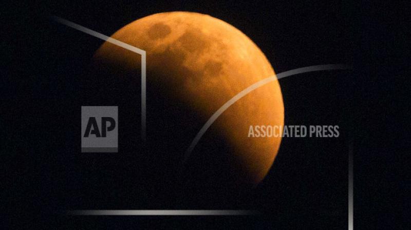 The moon turns a reddish hue as it passes through the earths shadow during a lunar eclipse as seen in Gauhati, India.