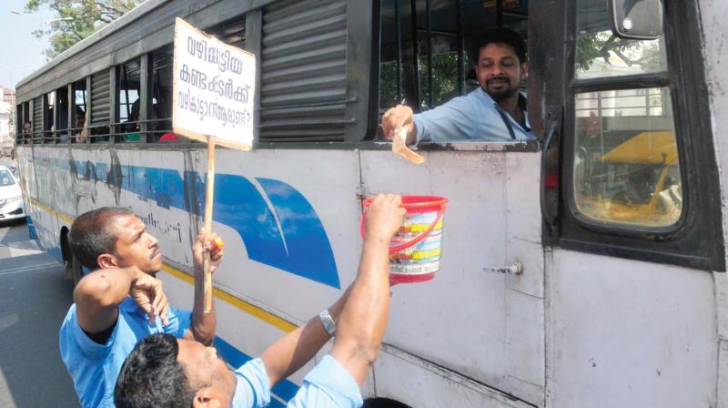 Dismissed empanelled conductors of the KSRTC, who are on an indefinite strike in front of the Secretariat, make a collection from a transport bus driver on Thursday.   (A.V.MUZAFAR)