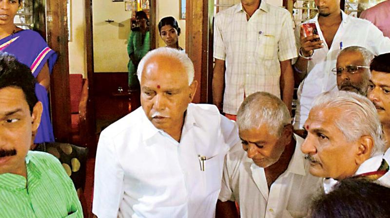 State BJP president B.S. Yeddyurappa and RSS leader Kalladka Prabhakar Bhat (right) at slain RSS worker Sharath Madivalas house in Bantwal near Mangaluru on Thursday   KPN