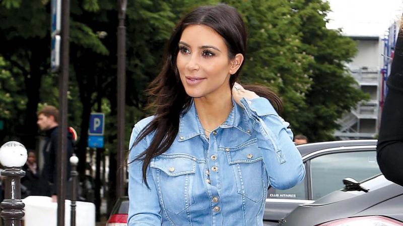 Kim Kardasshian keeps it simple by pairin her outfit with a pair of sunglasses.