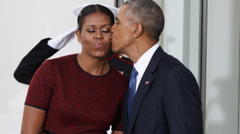 President Barack Obama kisses first lady Michelle Obama as they wait for President-elect Donald Trump and his wife Melania Trump at the White House. (Photo: AP)