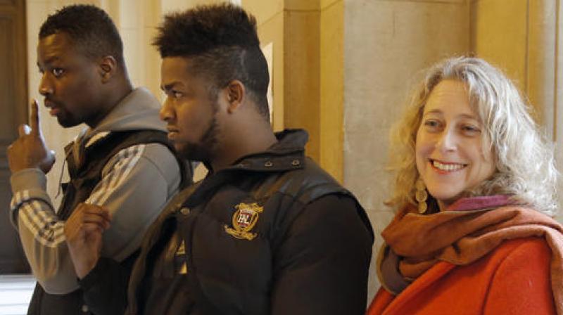 Plaintiffs Regis Amponsah, left, and Elize Novembre, right, stand with Lanna Hollo, senior legal officer with Open Society Justice Initiative, and talk to the media at Paris appeals court. (Photo: AP)