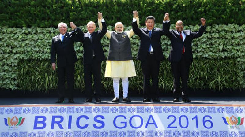 Leaders of BRICS countries, from left, Brazilian President Michel Temer, Russian President Vladimir Putin, Indian Prime Minister Narendra Modi, Chinese President Xi Jinping, and South African President Jacob Zuma raise their hand for a group photo at the start of the BRICS Summit in Goa. (Photo: PTI)