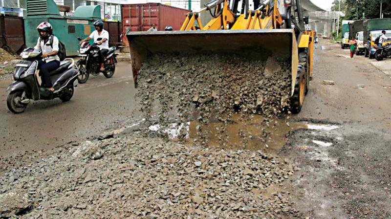 The pothole filling work being carried out at Rajajrajeshwari Gate on Mysuru Road