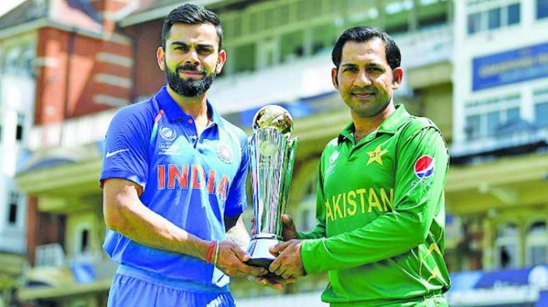 A file photo of India captain Virat Kohli and his counterpart Sarfaraz Ahmed posing with the Champions Trophy. (Photo: AFP)