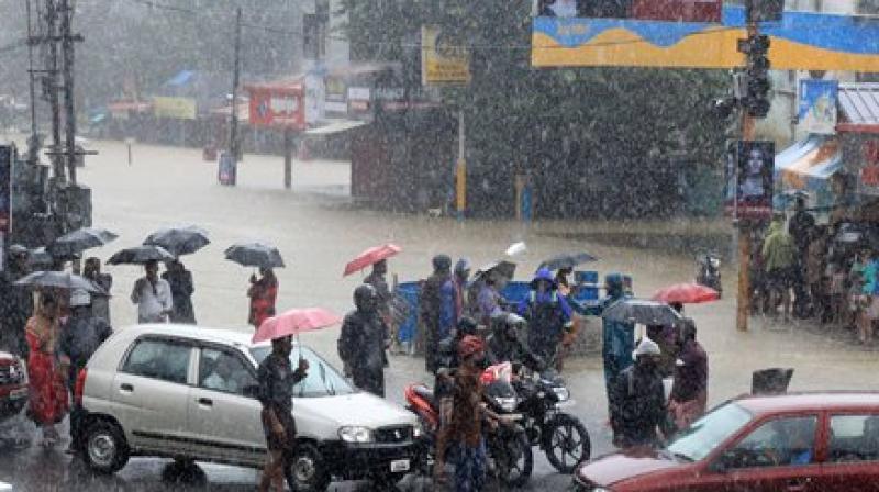 People stranded at a flooded junction following a flash flood, triggered by heavy rains, at Palakkad in Kerala. (Photo: PTI)