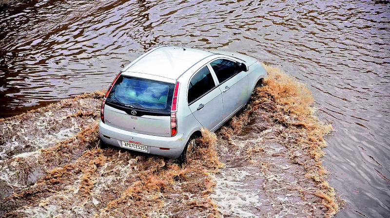 A four-wheeler driver wades through rainwater that stagnated at Krishnalanka highway due to heavy rains in the past two days in Vijayawada. (Photo: DC)