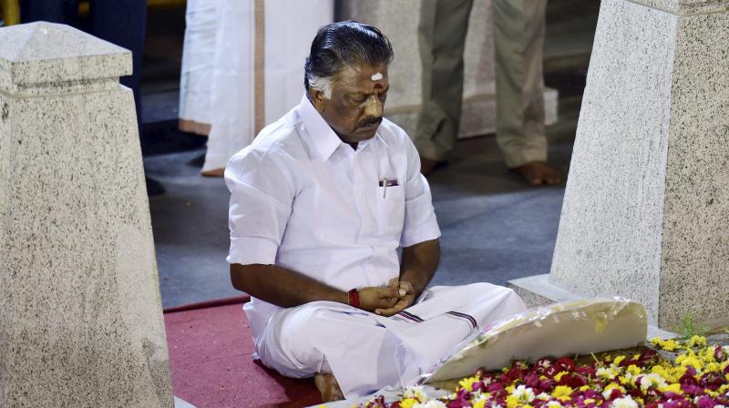 Tamil Nadu Chief Minister O Panneerselvam sitting in a meditation in front of late J Jayalalithaas burial site at the Marina Beach in Chennai. (Photo: PTI)