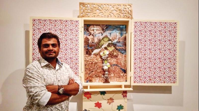 Artist Naveen Kumar with one of his works