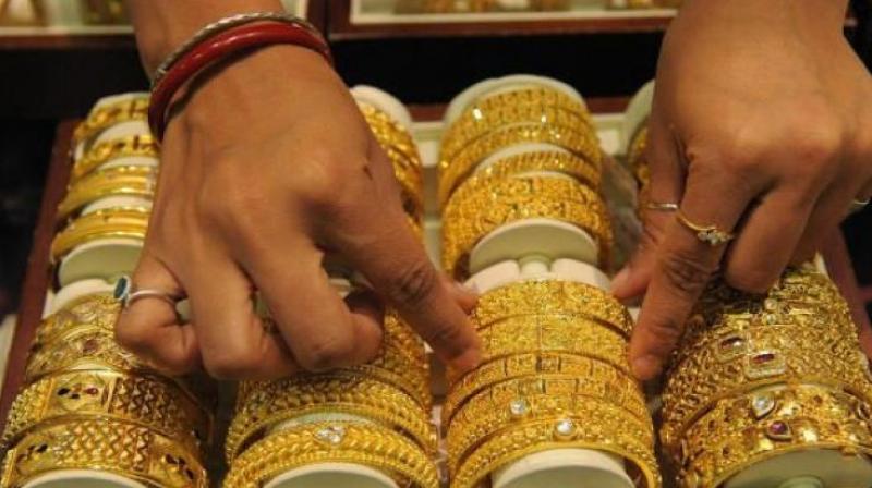 Gold climbs in futures trade on firm global cues