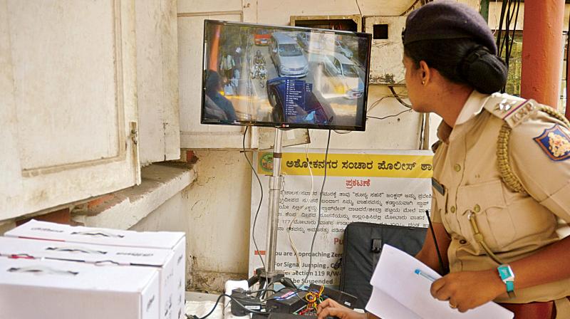 A policewoman inspecting the surveillance cameras and loud speakers installed at Brigade Road and MG Road in Bengaluru on Saturday (Photo: DC)