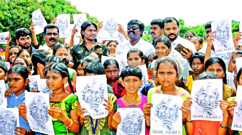 Students pay homage to Dr A.J.P. Abdul Kalam by holding his posters in Khammam on Sunday. (Photo: DC)