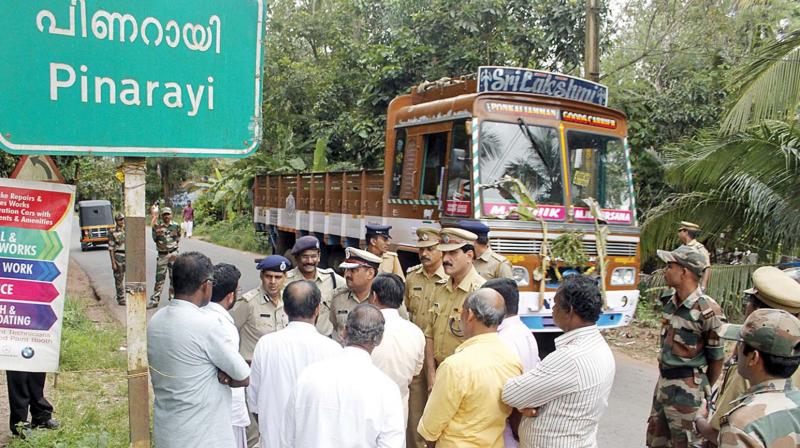 Police guard the entrance to Pinarayi village following a political killing in the area. (Photo: DC)